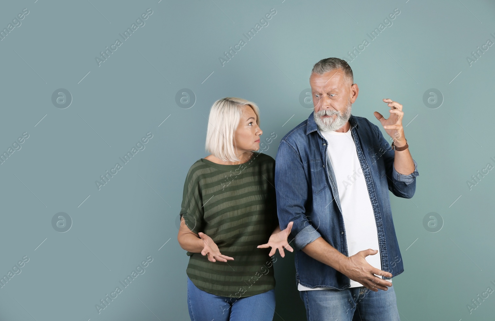 Photo of Mature couple having argument on color background. Relationship problems