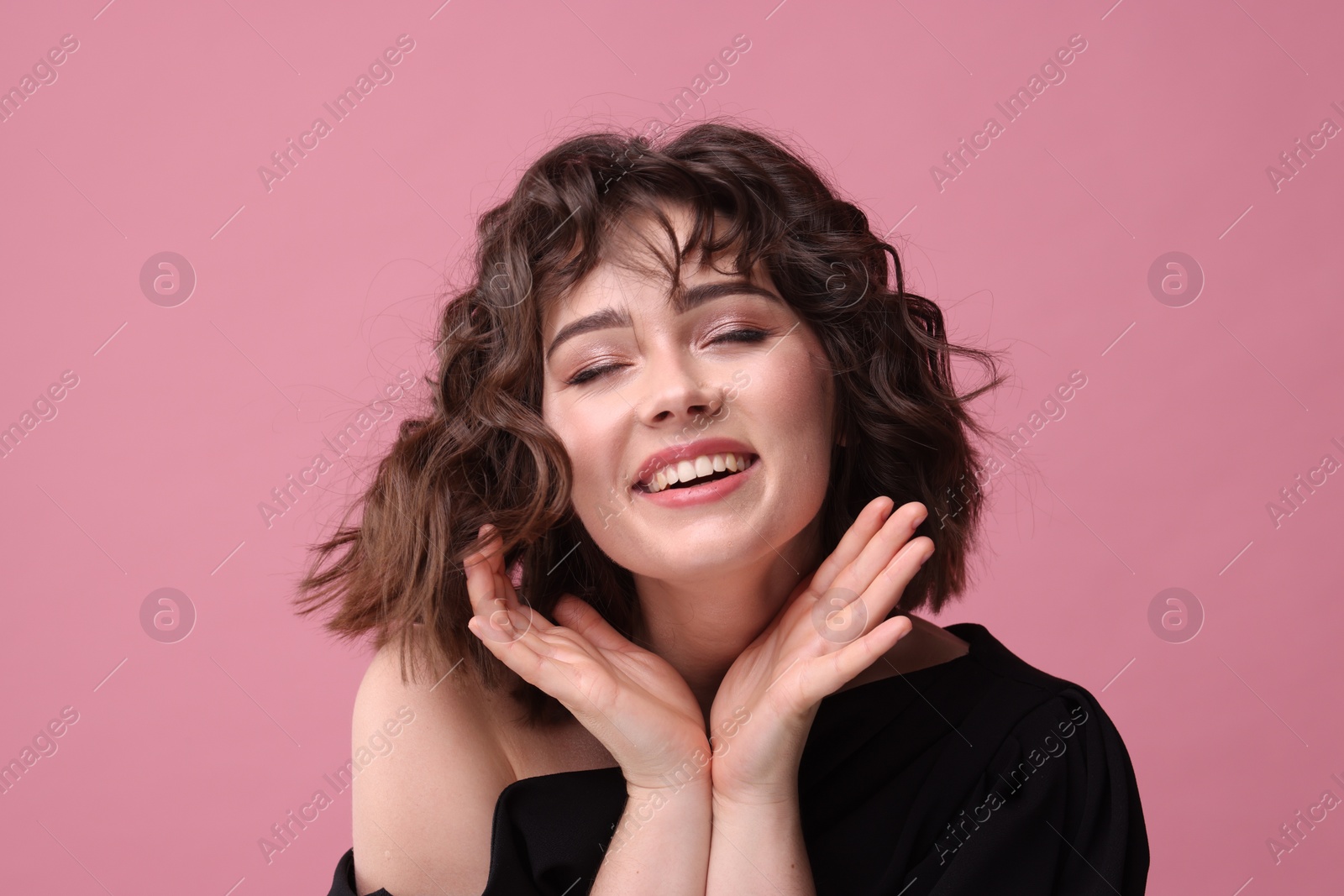 Photo of Portrait of beautiful young woman with wavy hairstyle on pink background