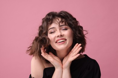 Photo of Portrait of beautiful young woman with wavy hairstyle on pink background