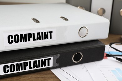 Image of Folders with Complaint labels on office desk, closeup