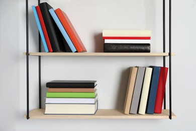 Shelves with many hardcover books on white wall
