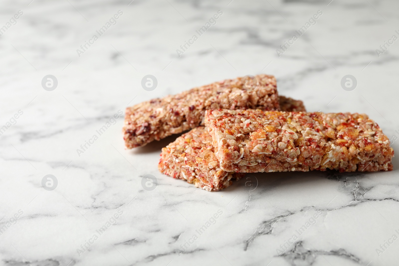 Photo of Tasty protein bars on marble table. Space for text