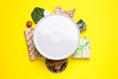 Photo of Frame made with symbolic Passover items on yellow background, space for text. Pesah celebration