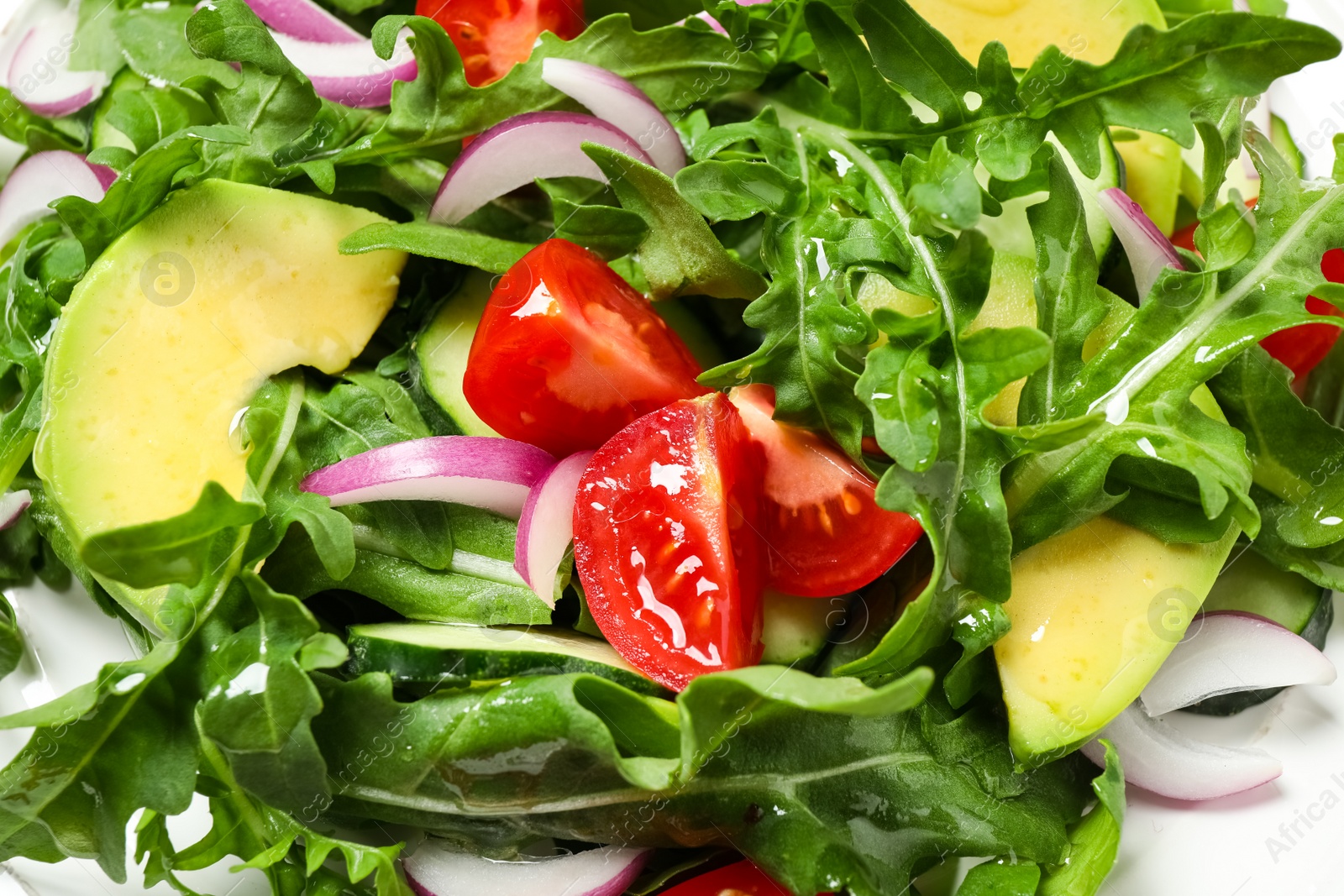 Photo of Delicious salad with avocado, arugula and tomatoes on plate, closeup