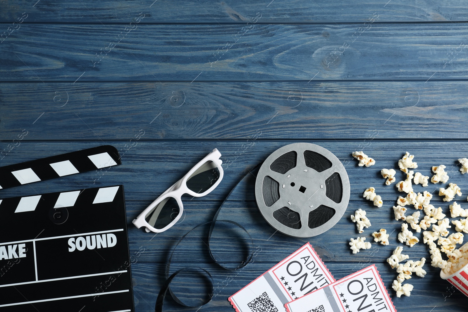 Photo of Flat lay composition with clapperboard and cinema tickets on blue wooden background, space for text