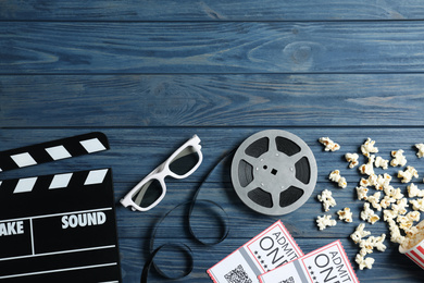 Photo of Flat lay composition with clapperboard and cinema tickets on blue wooden background, space for text
