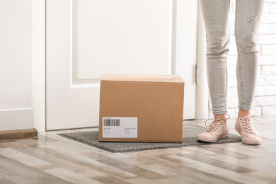 Photo of Woman with parcel near door, closeup Delivery service