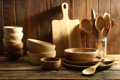 Many different wooden dishware and utensils on table