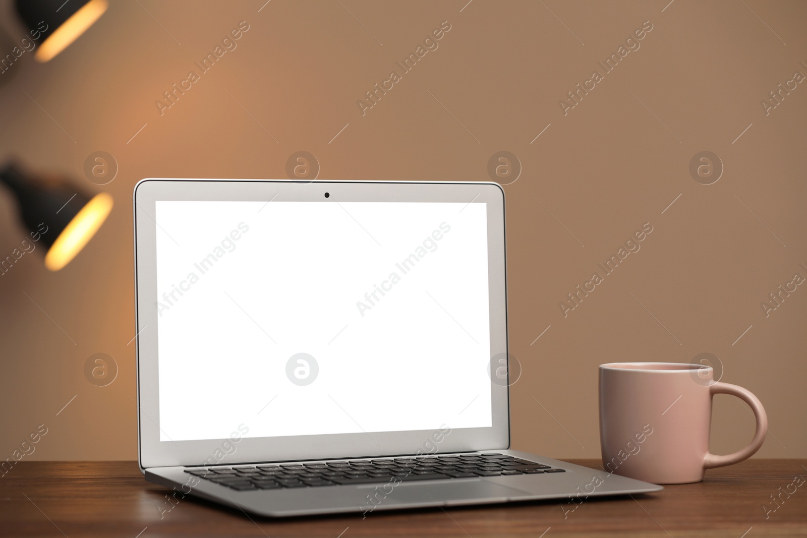 Photo of Laptop with blank screen on table indoors. Space for text