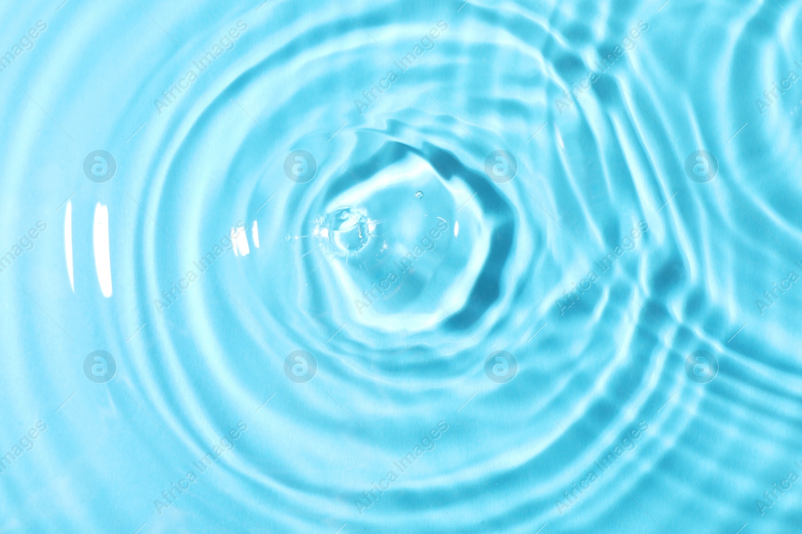 Photo of Closeup view of water with rippled surface on light blue background