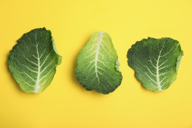 Photo of Green leaves of savoy cabbage on color background, top view