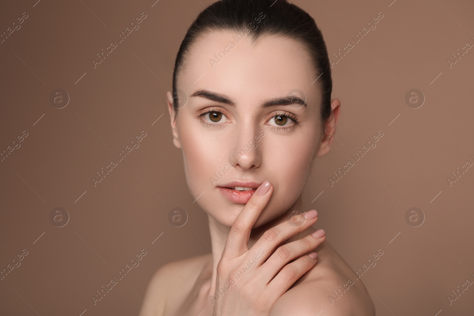 Photo of Portrait of beautiful young woman on brown background