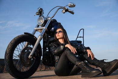 Photo of Beautiful woman sitting near motorcycle on sunny day