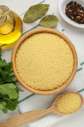 Photo of Raw couscous and ingredients on white wooden table, flat lay