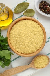 Raw couscous and ingredients on white wooden table, flat lay