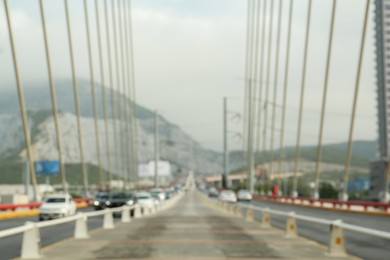 Photo of Blurred view of modern bridge near mountain