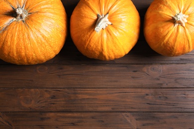 Flat lay composition with pumpkins and space for text on wooden background. Autumn holidays