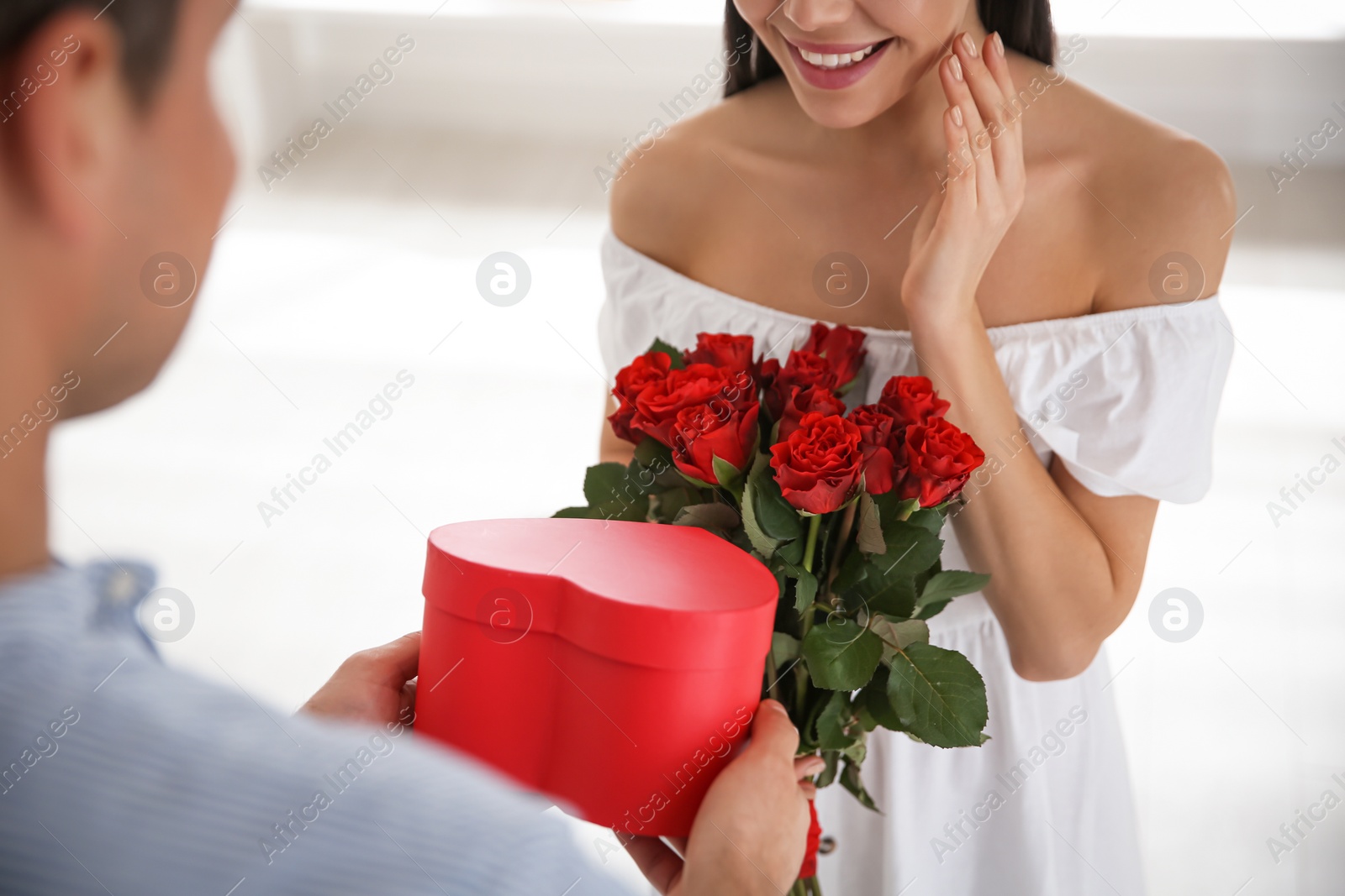 Photo of Man presenting gift to his beloved woman at home, closeup. Valentine's day celebration