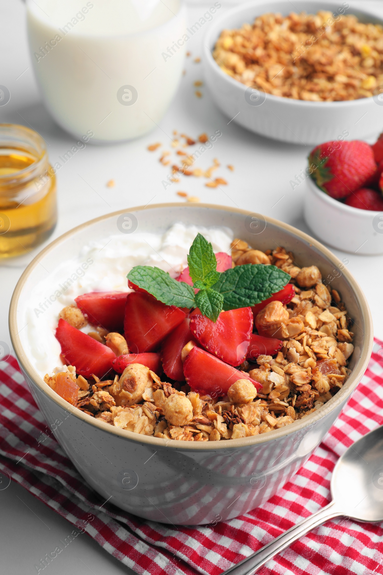 Photo of Bowl with tasty granola and strawberries on table. Healthy meal