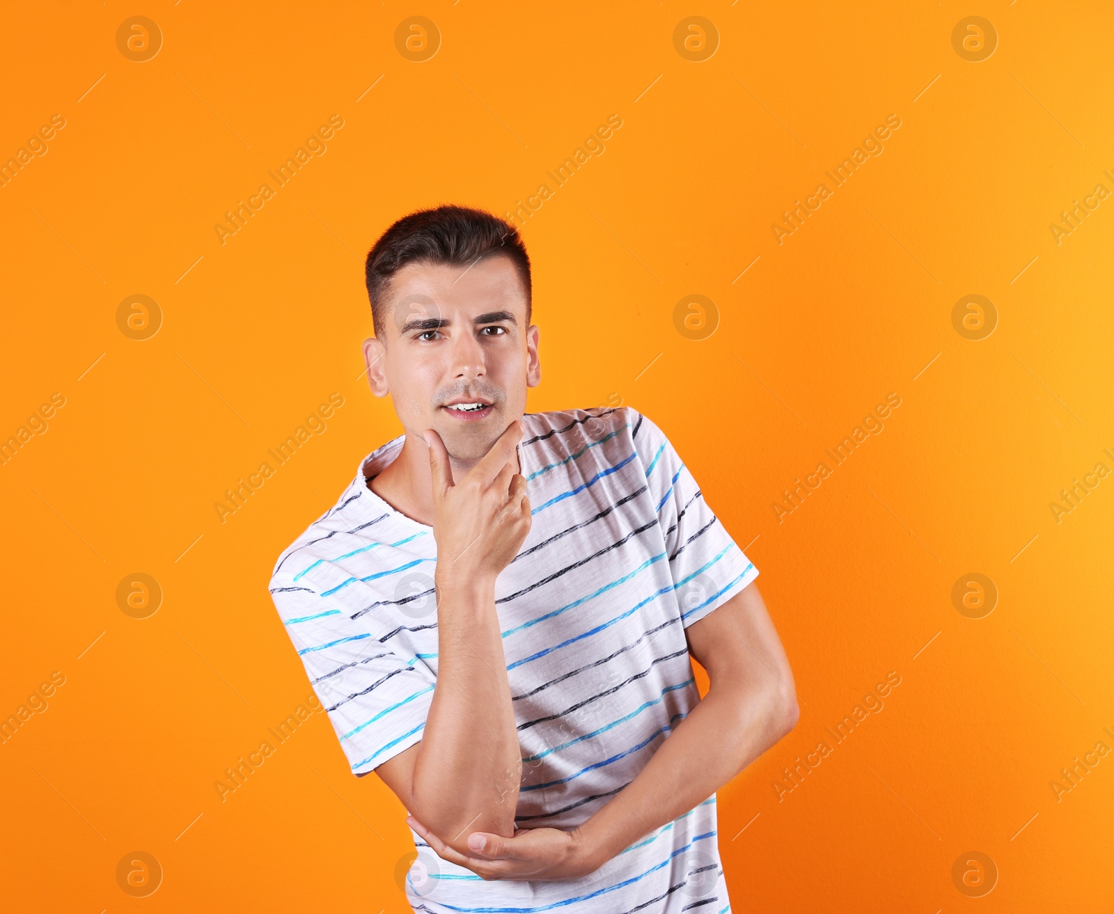 Photo of Thoughtful handsome young man on color background