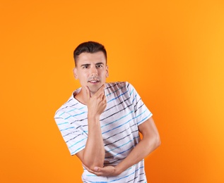 Photo of Thoughtful handsome young man on color background