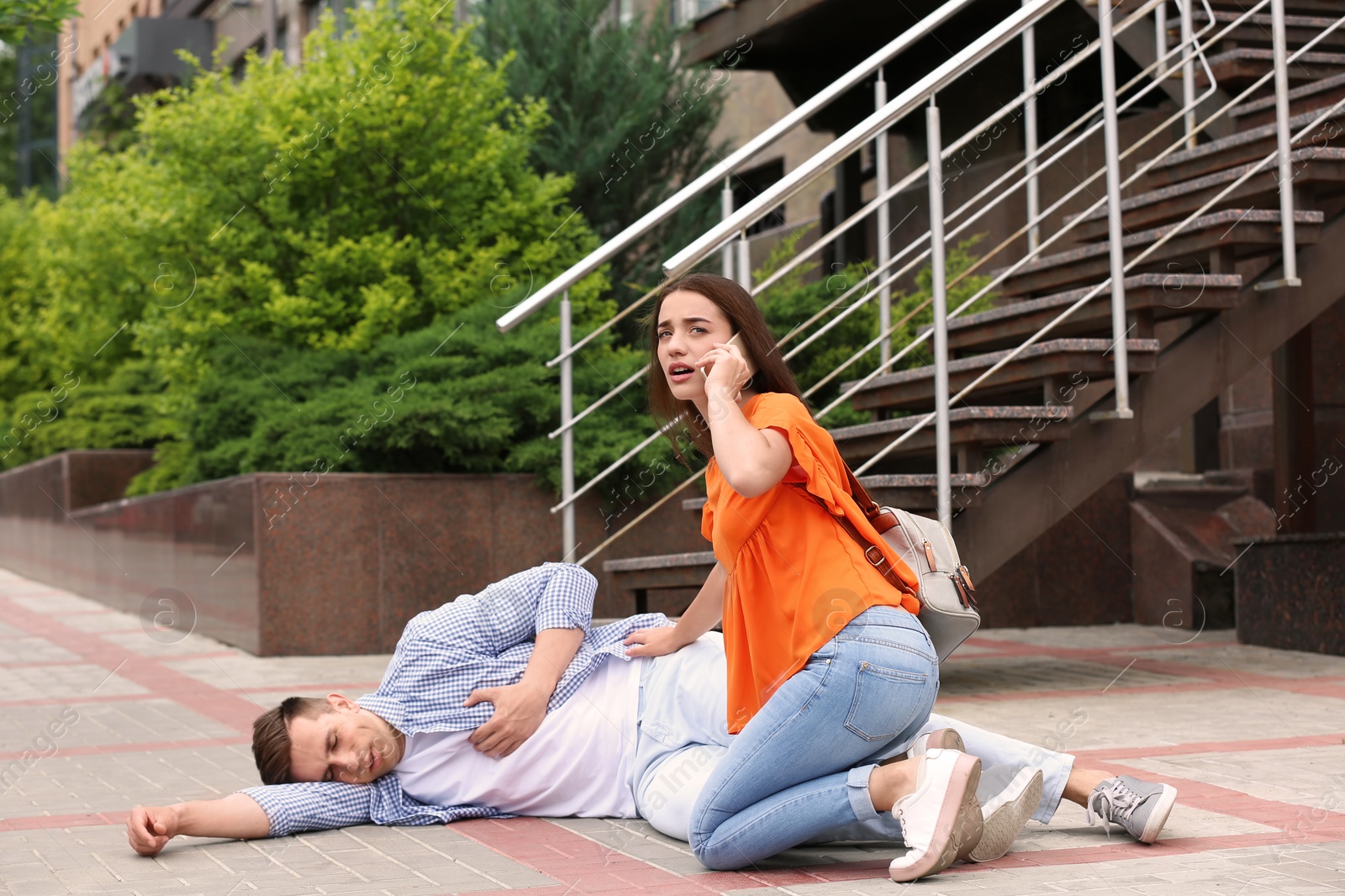 Photo of Passerby calling ambulance for man having heart attack outdoors