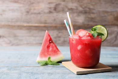 Photo of Summer watermelon drink in glass on table against wooden background with space for text