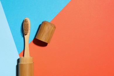 Photo of Bamboo toothbrush in case on color background, top view. Space for text
