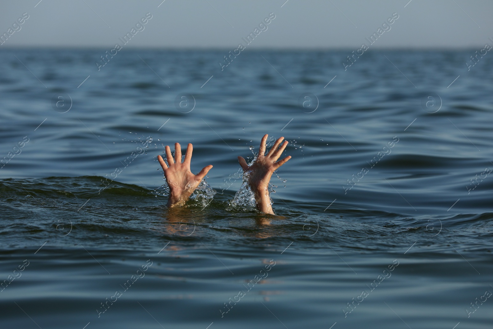 Photo of Drowning woman reaching for help in sea