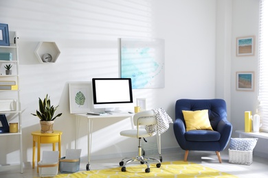 Photo of Comfortable office chair near desk with modern computer indoors