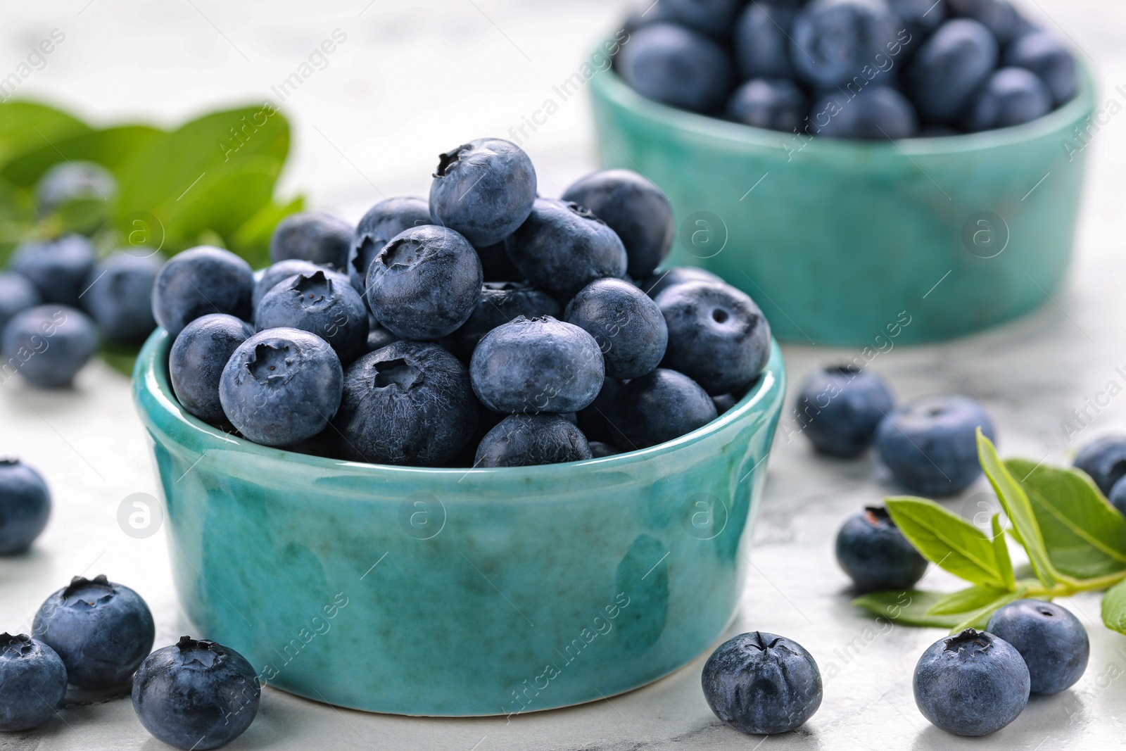 Photo of Tasty fresh blueberries on white marble table, closeup