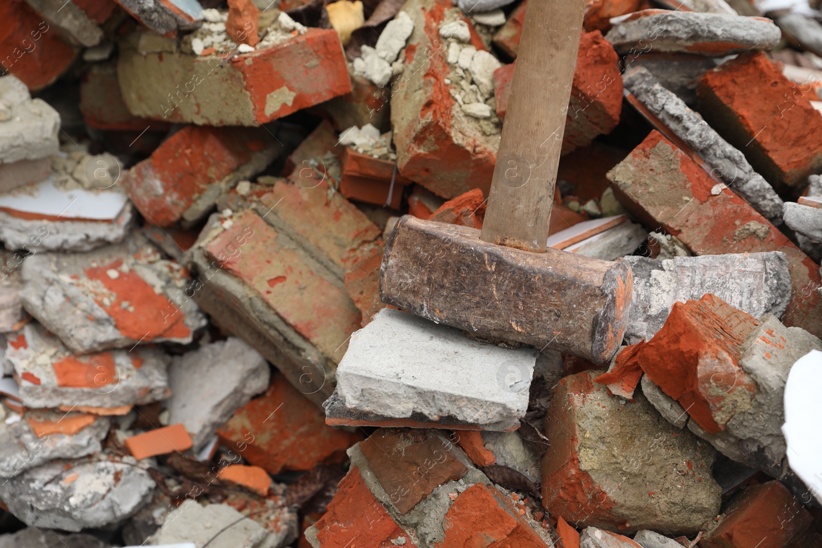 Photo of Sledgehammer on pile of broken bricks, closeup