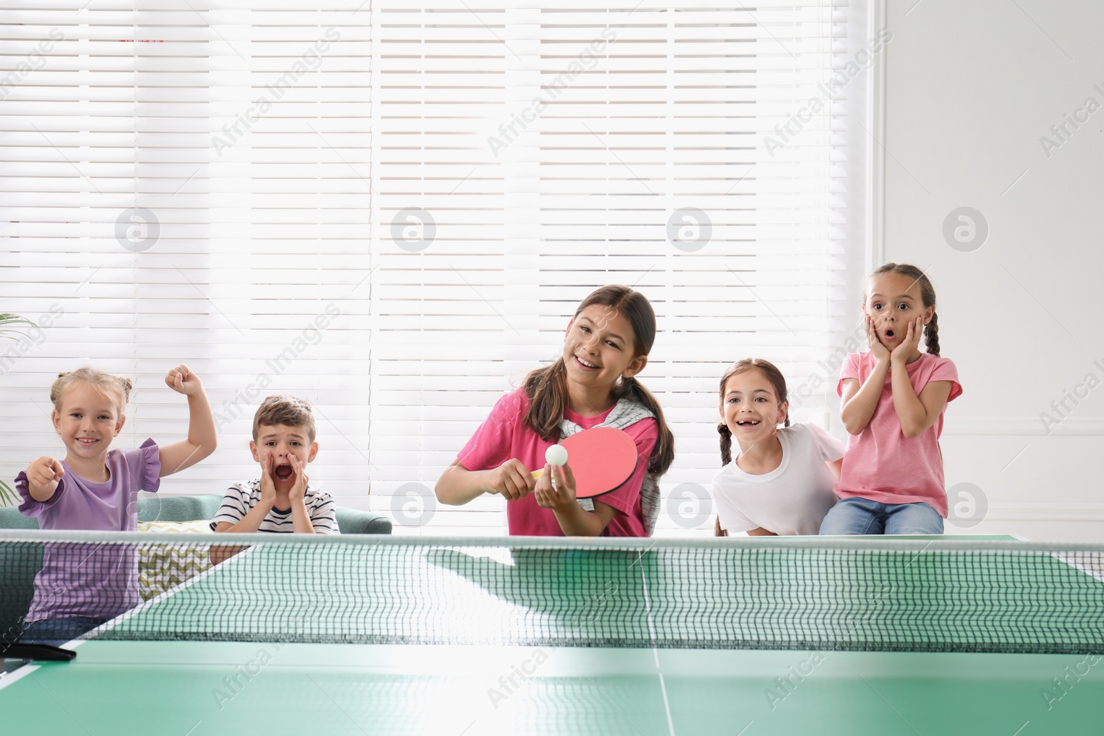 Photo of Cute happy children playing ping pong indoors