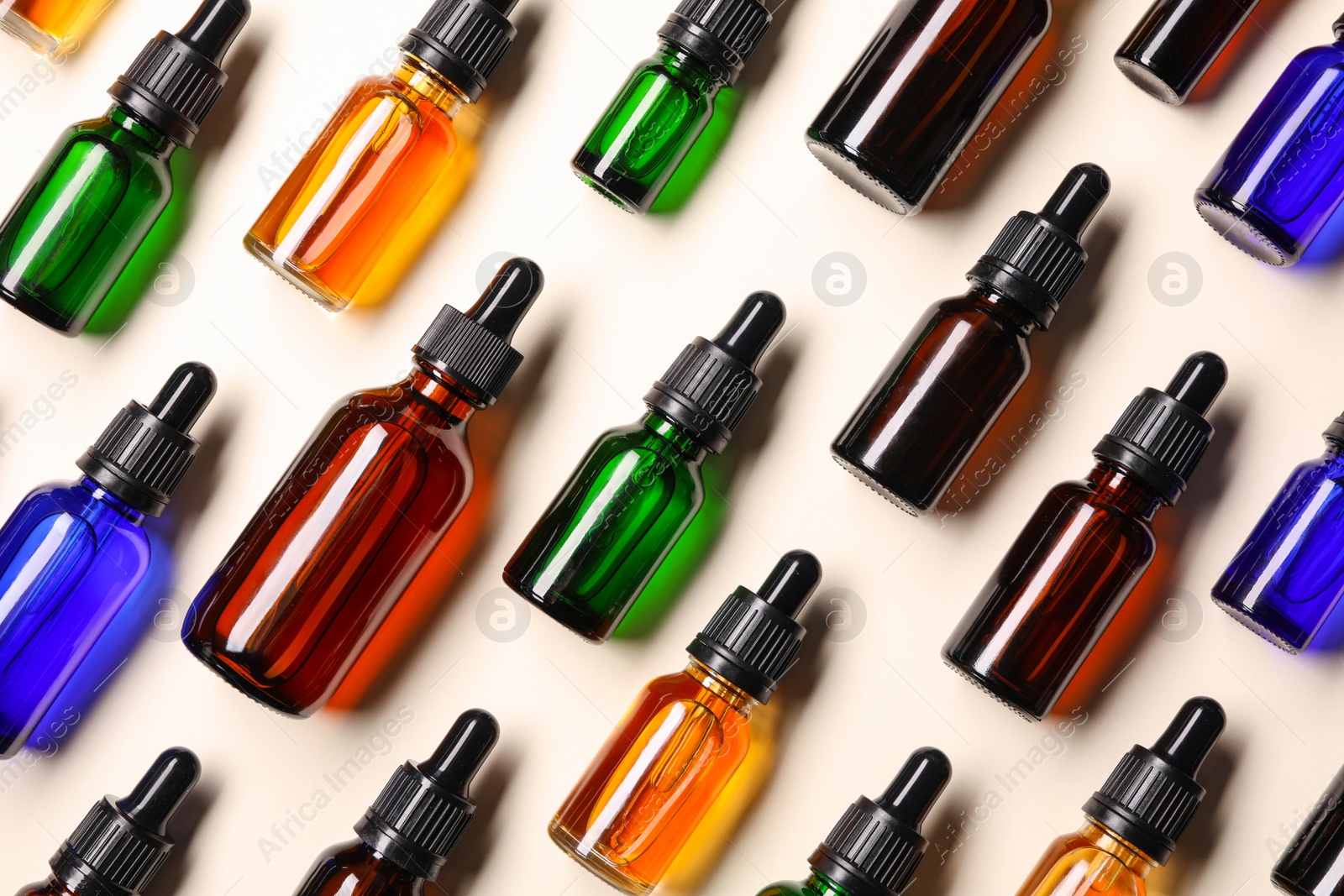 Photo of Flat lay composition with cosmetic bottles of essential oils on color background