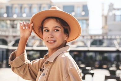 Portrait of happy young woman on city street