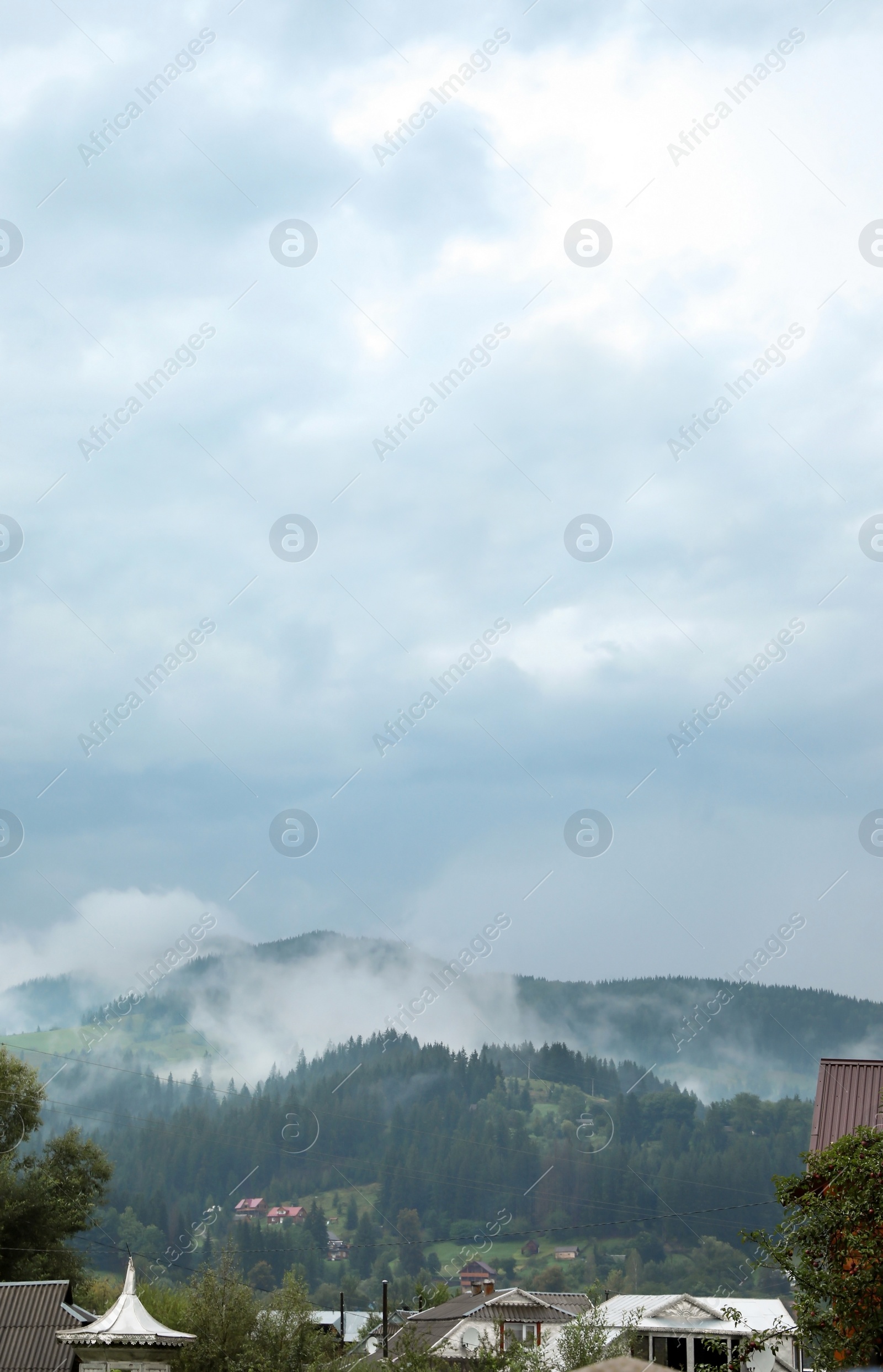 Photo of Picturesque view of village near mountains in foggy morning