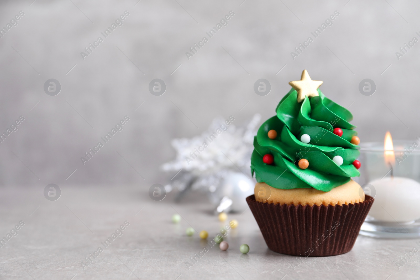 Photo of Christmas tree shaped cupcake on light grey table. Space for text
