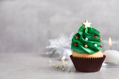 Christmas tree shaped cupcake on light grey table. Space for text