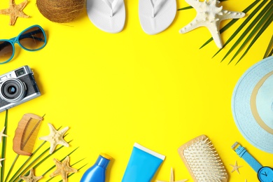 Photo of Flat lay composition with beach accessories on yellow background, space for text