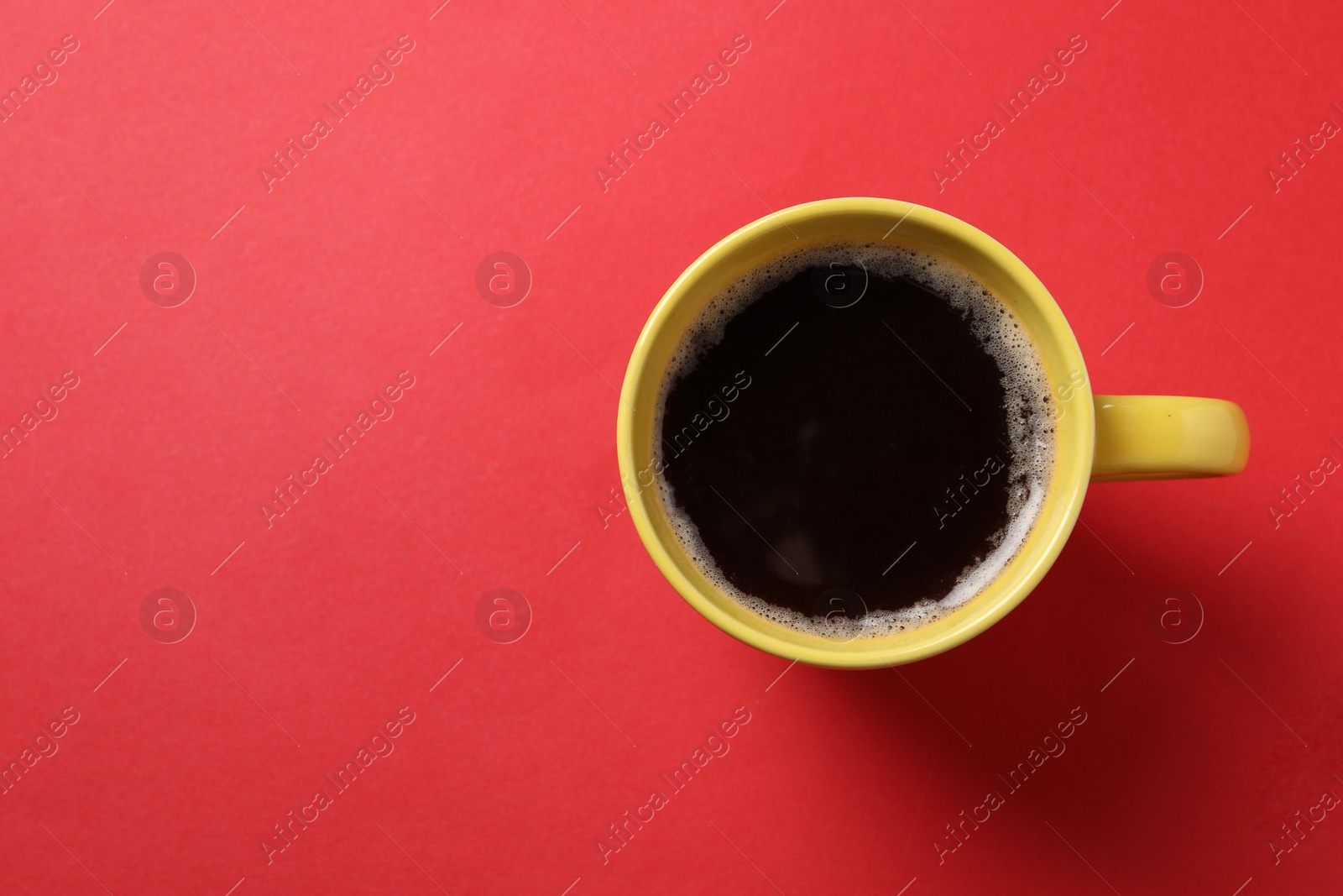 Photo of Cup of aromatic coffee on red background, top view. Space for text