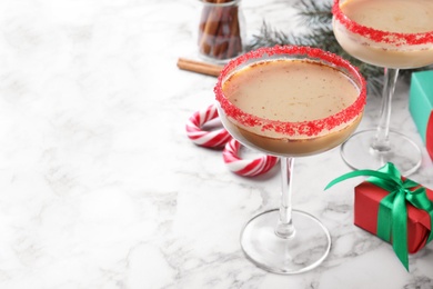 Photo of Delicious Christmas liqueur on white marble table, closeup. Space for text