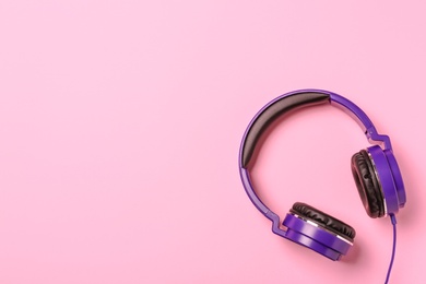 Photo of Stylish modern headphones on color background, top view. Space for text