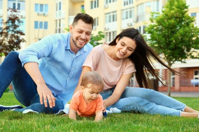 Photo of Parents helping their adorable little baby to crawl outdoors