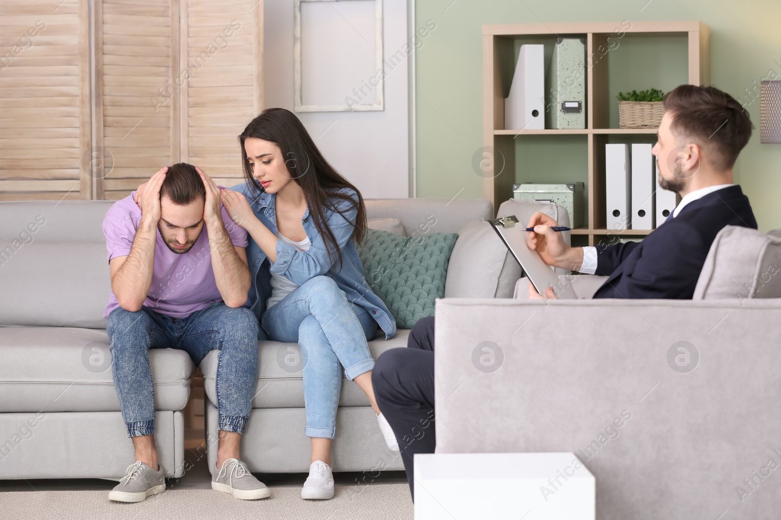 Photo of Family psychologist working with young couple in office