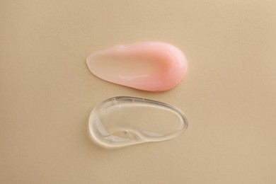 Photo of Samples of cosmetic gels on beige background, top view