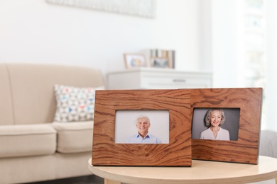 Photo of Portraits in wooden frames on table indoors