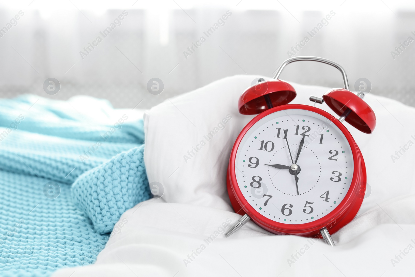 Photo of Alarm clock on bed. Time to wake up