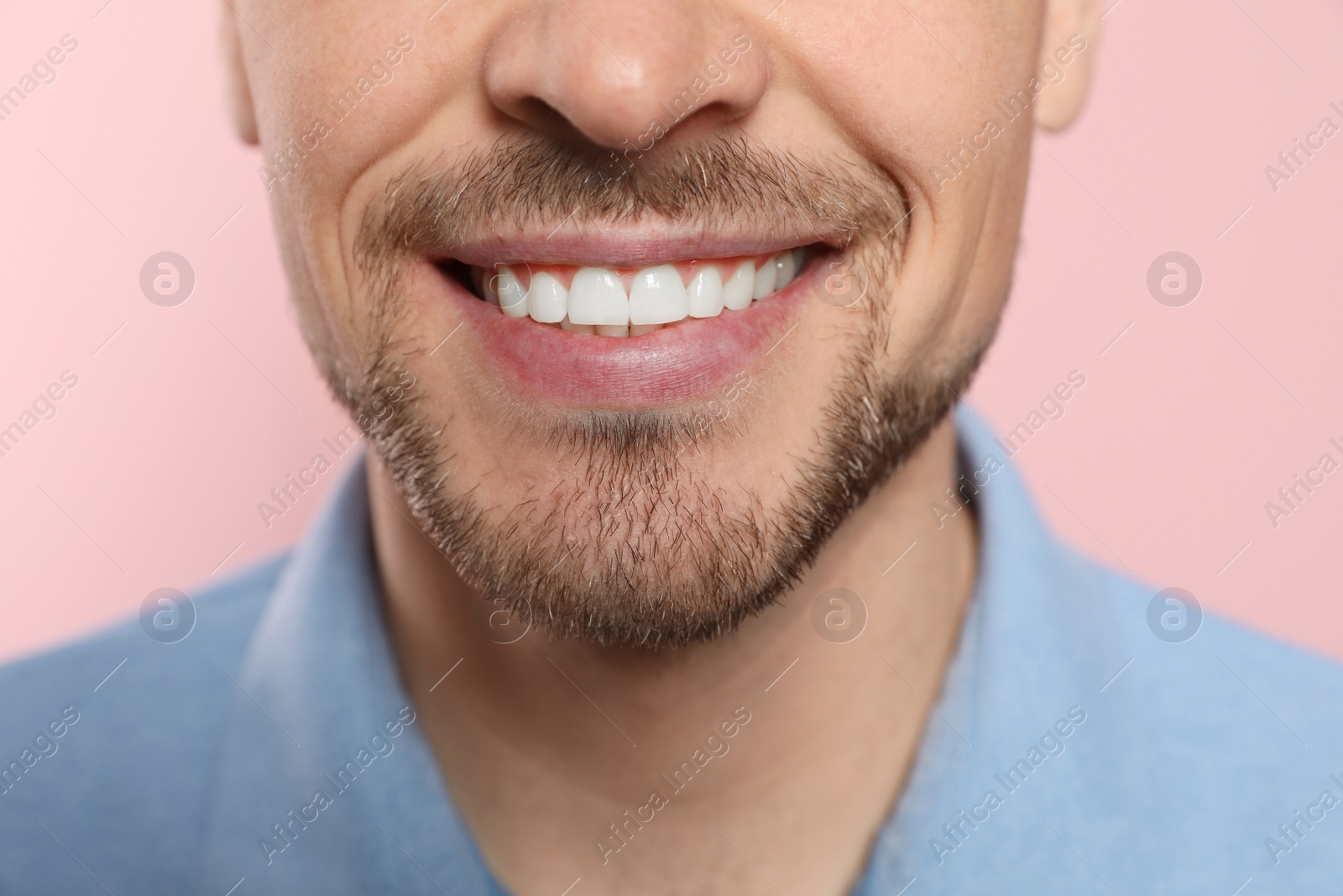 Photo of Smiling man with perfect teeth on color background, closeup