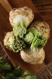 Photo of Fresh raw celery roots on wooden table, top view