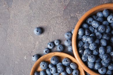 Photo of Flat lay composition with juicy blueberries and space for text on color table
